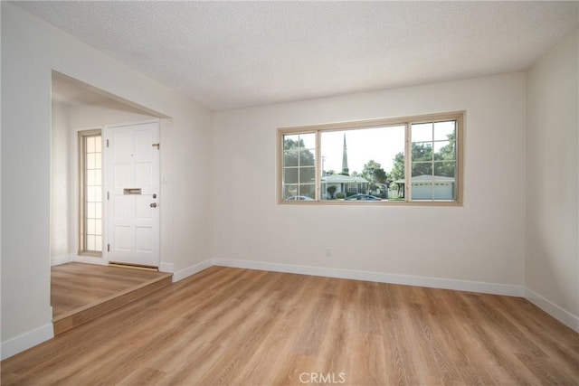 25070 Tulip Ave, Loma Linda, CA 92354 - empty room featuring light wood-type flooring and a textured ceiling