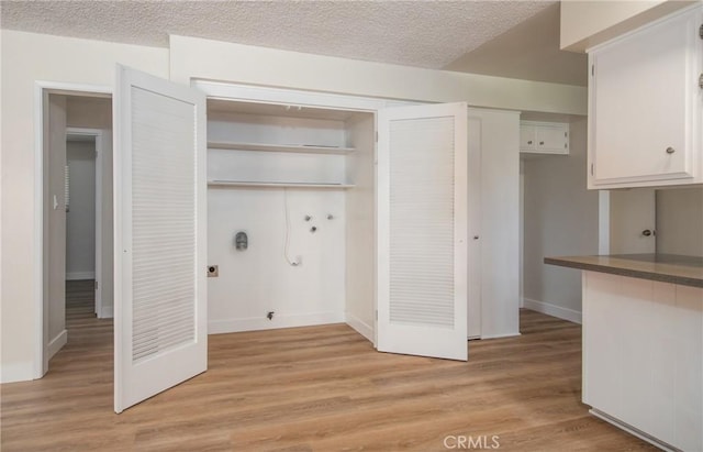 25070 Tulip Ave, Loma Linda, CA 92354 - laundry area with hookup for a washing machine, light wood finished floors, electric dryer hookup, hookup for a gas dryer, and a textured ceiling