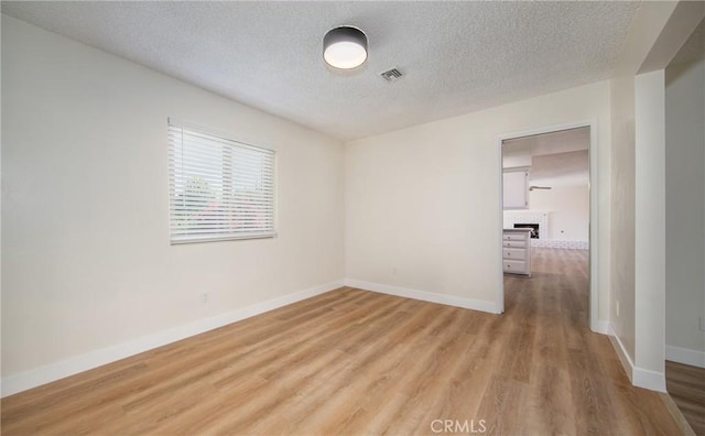 25070 Tulip Ave, Loma Linda, CA 92354 - unfurnished room featuring light wood-type flooring and a textured ceiling
