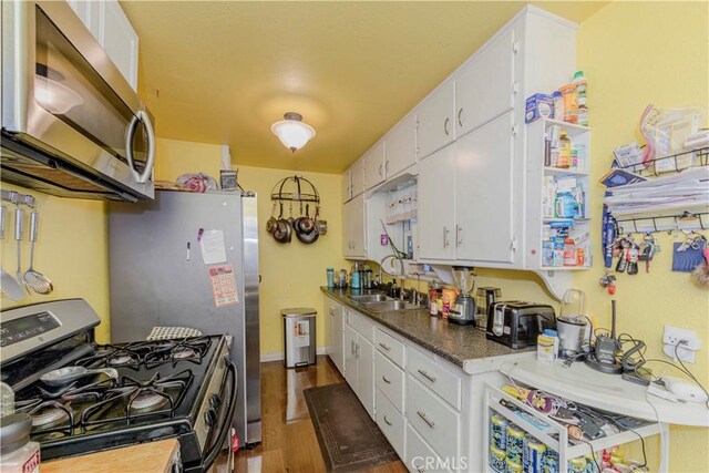 1493 W Grand Ave, Pomona, CA 91766 - kitchen with stainless steel appliances, wood finished floors, white cabinets, and dark countertops