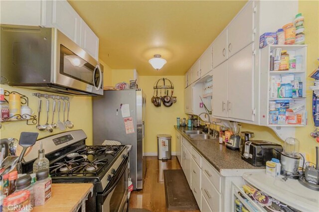 1493 W Grand Ave, Pomona, CA 91766 - kitchen with appliances with stainless steel finishes, white cabinetry, and dark wood-style floors