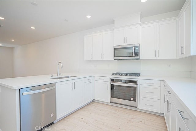 1239 Bonnet Way, Torrance, CA 90502 - kitchen with stainless steel appliances, a peninsula, white cabinets, light wood finished floors, and recessed lighting