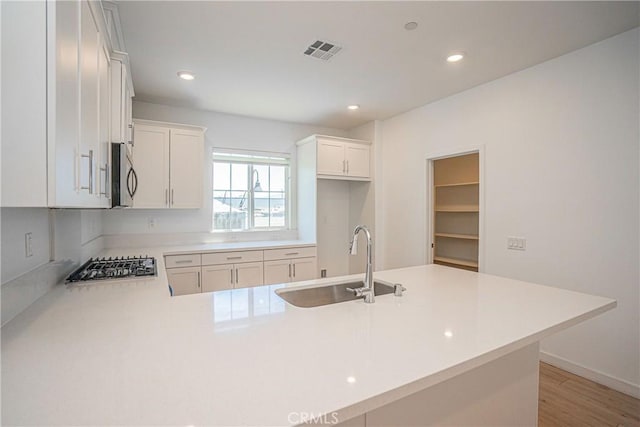 1239 Bonnet Way, Torrance, CA 90502 - kitchen with appliances with stainless steel finishes, light countertops, recessed lighting, a peninsula, and light wood-type flooring