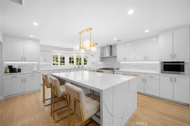 17437 Chase St, Northridge, CA 91325 - kitchen with wall chimney exhaust hood, stainless steel oven, white cabinetry, a kitchen island, and recessed lighting