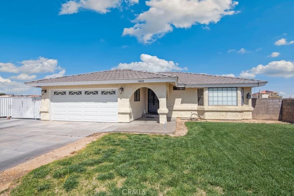 14672 Rivers Edge Rd, Helendale, CA 92342 - view of front of house featuring an attached garage, stucco siding, concrete driveway, and a tile roof