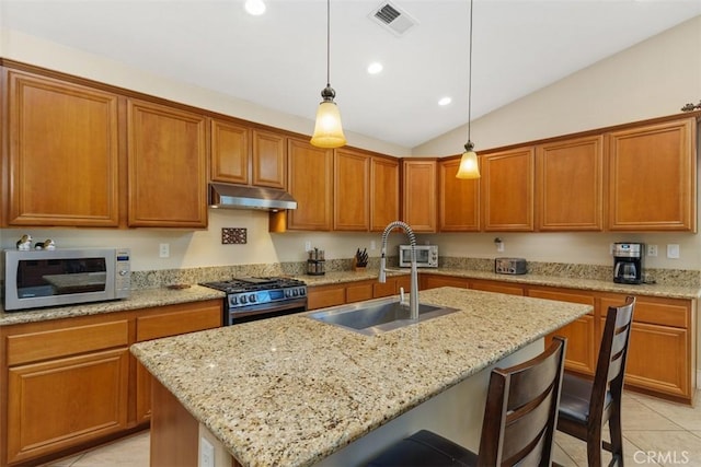 31676 Brentworth St, Menifee, CA 92584 - kitchen with white microwave, stainless steel gas range, under cabinet range hood, light tile patterned floors, and a kitchen breakfast bar