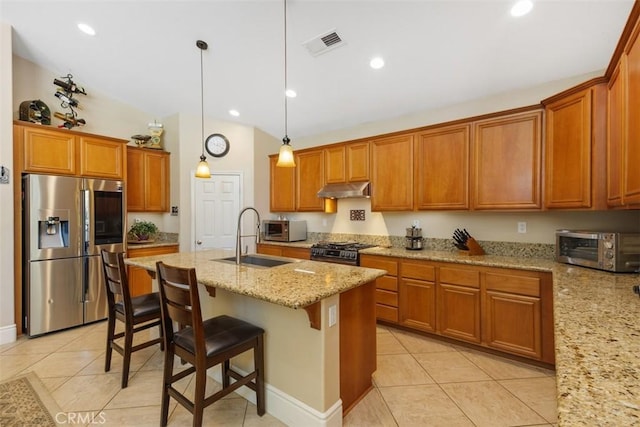 31676 Brentworth St, Menifee, CA 92584 - kitchen featuring appliances with stainless steel finishes, under cabinet range hood, light tile patterned floors, brown cabinets, and lofted ceiling