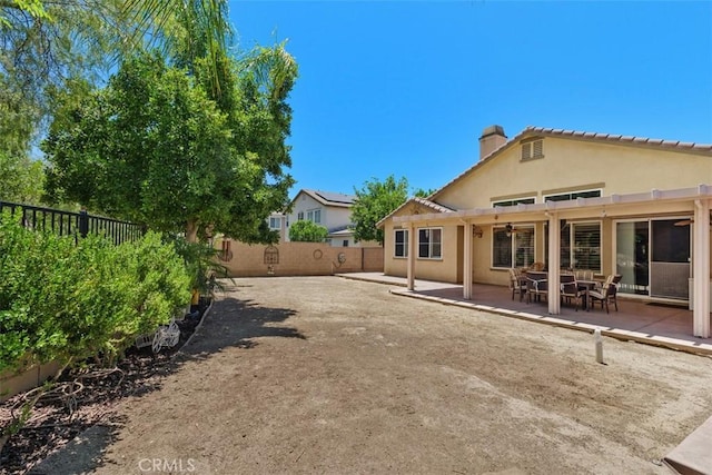 31676 Brentworth St, Menifee, CA 92584 - rear view of house featuring stucco siding, a fenced backyard, a chimney, and a patio