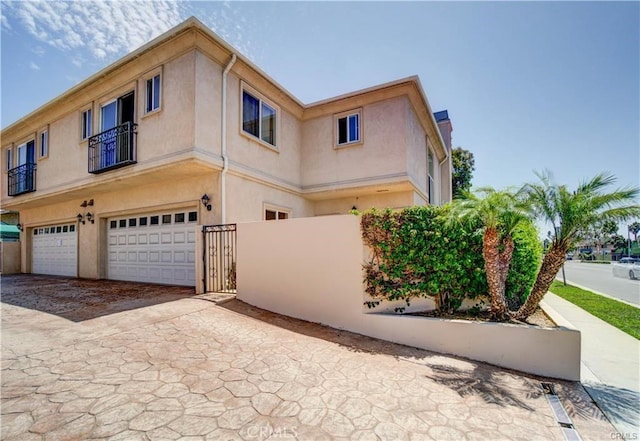 16714 Inglewood Ave Unit A, Lawndale, CA 90260 - view of side of home featuring stucco siding, an attached garage, and driveway