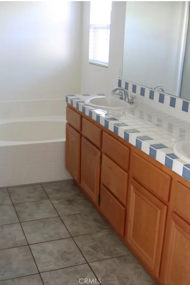 2237 Pajaro St, Oxnard, CA 93030 - bathroom featuring double vanity, tile patterned flooring, and a relaxing tiled tub
