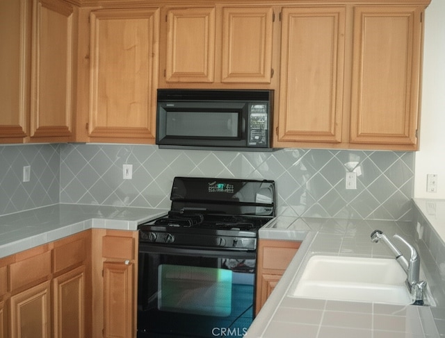 2237 Pajaro St, Oxnard, CA 93030 - kitchen with black appliances, tile counters, and tasteful backsplash