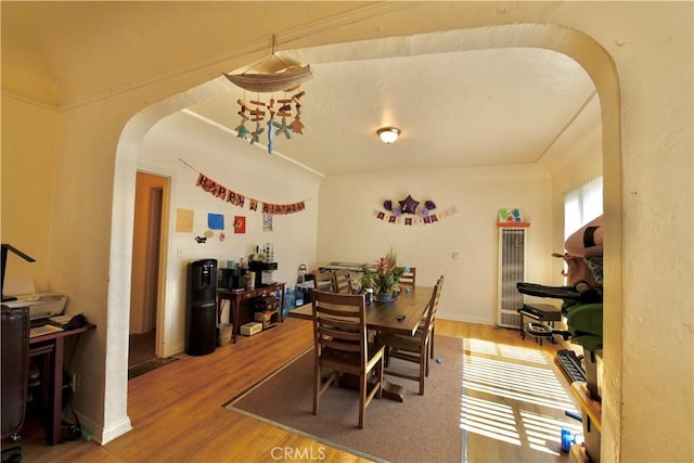 3945 Woolwine Dr, Los Angeles, CA 90063 - dining room featuring arched walkways, wood finished floors, and a heating unit