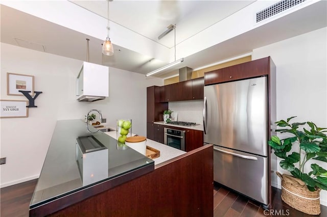 1155 S Grand Ave Unit 1008, Los Angeles, CA 90015 - kitchen with stainless steel appliances, a peninsula, dark wood finished floors, hanging light fixtures, and light countertops