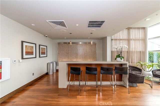1155 S Grand Ave Unit 1008, Los Angeles, CA 90015 - kitchen featuring wood finished floors, a breakfast bar, and recessed lighting