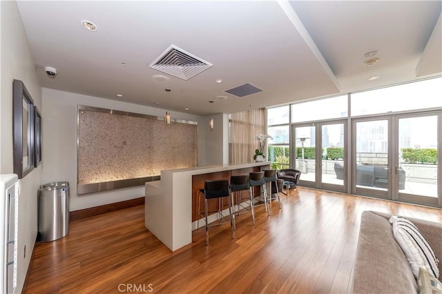 1155 S Grand Ave Unit 1008, Los Angeles, CA 90015 - kitchen with wood-type flooring, a breakfast bar area, light countertops, recessed lighting, and a kitchen island