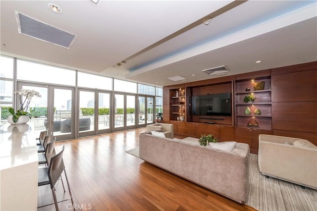 1155 S Grand Ave Unit 1008, Los Angeles, CA 90015 - living area featuring floor to ceiling windows, wood finished floors, and built in shelves