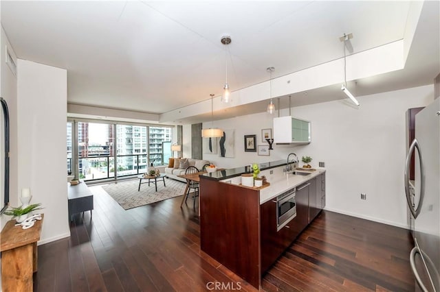 1155 S Grand Ave Unit 1008, Los Angeles, CA 90015 - kitchen featuring stainless steel appliances, open floor plan, dark wood-style floors, pendant lighting, and light countertops