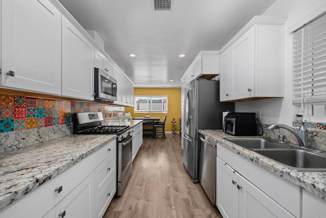 102 Sierra Way, Chula Vista, CA 91911 - kitchen featuring stainless steel appliances, recessed lighting, white cabinetry, light wood-style floors, and tasteful backsplash