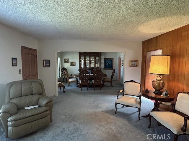 1220 W L St, Wilmington, CA 90744 - living room with light colored carpet, wood walls, and a textured ceiling