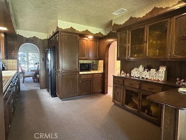 1220 W L St, Wilmington, CA 90744 - kitchen with arched walkways, stainless steel microwave, freestanding refrigerator, backsplash, and a textured ceiling