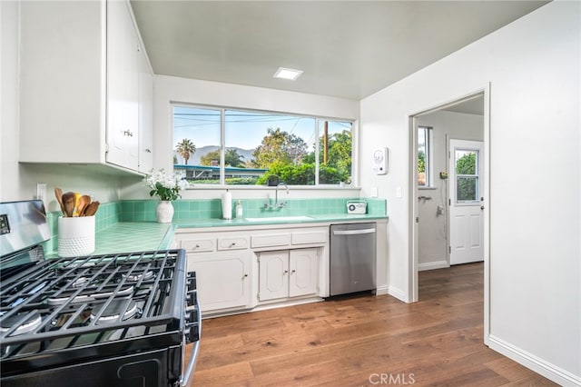 817 W Hollyvale St, Glendora, CA 91740 - kitchen featuring stainless steel appliances, tile countertops, white cabinets, tasteful backsplash, and light wood-style floors