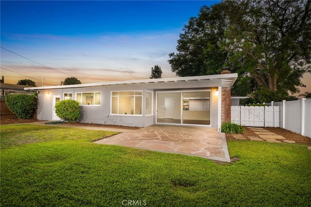 817 W Hollyvale St, Glendora, CA 91740 - back of property at dusk featuring a patio, a fenced backyard, stucco siding, and a chimney
