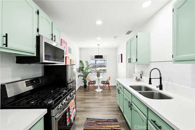 16874 Athol St, Fontana, CA 92335 - kitchen with appliances with stainless steel finishes, green cabinets, light countertops, wood finished floors, and recessed lighting