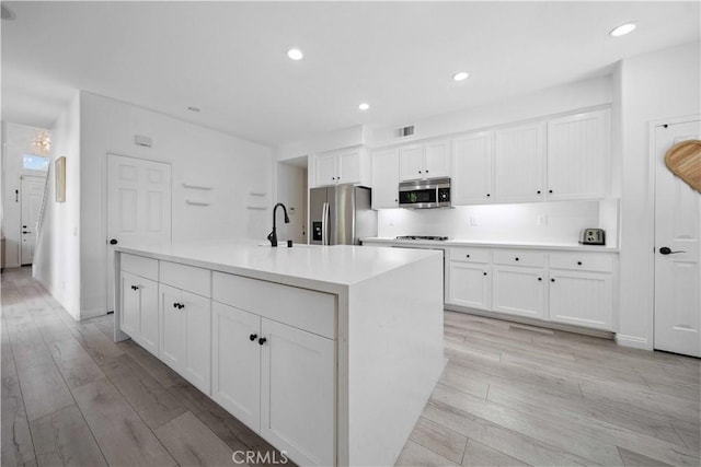 21 Dawnwood, Ladera Ranch, CA 92694 - kitchen featuring appliances with stainless steel finishes, white cabinets, light wood-style flooring, and recessed lighting
