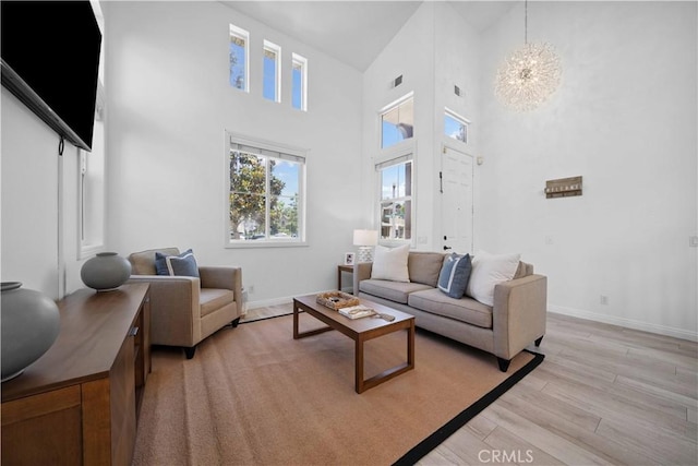 21 Dawnwood, Ladera Ranch, CA 92694 - living area featuring light wood-style floors, a towering ceiling, and a chandelier