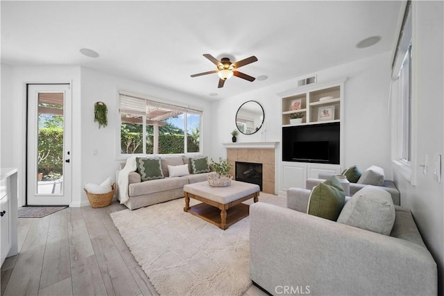 21 Dawnwood, Ladera Ranch, CA 92694 - living room with ceiling fan, a tiled fireplace, wood finished floors, and built in features