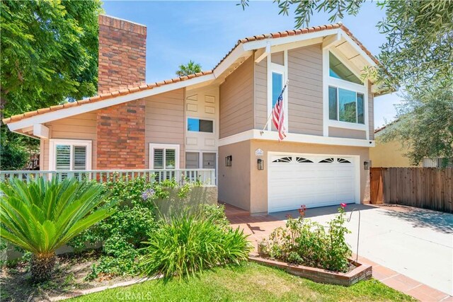 24046 Lindley St, Mission Viejo, CA 92691 - view of front of home featuring a tiled roof, an attached garage, a chimney, driveway, and stucco siding
