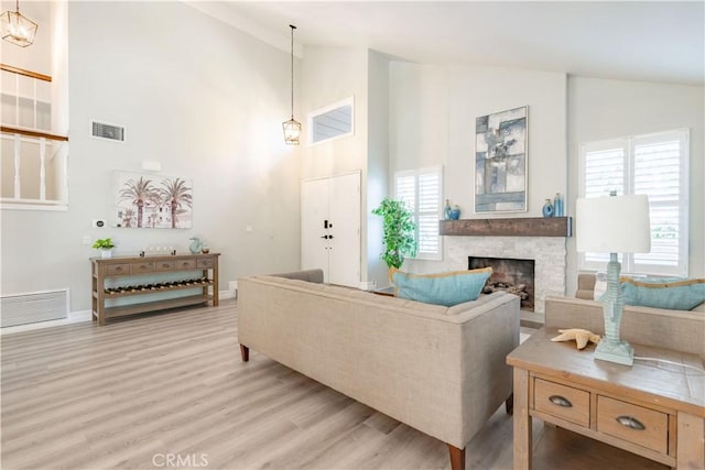 24046 Lindley St, Mission Viejo, CA 92691 - living area with high vaulted ceiling, light wood finished floors, a stone fireplace, and healthy amount of natural light