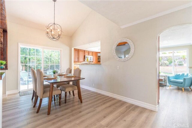 24046 Lindley St, Mission Viejo, CA 92691 - dining room featuring light wood-style flooring, a chandelier, healthy amount of natural light, arched walkways, and vaulted ceiling