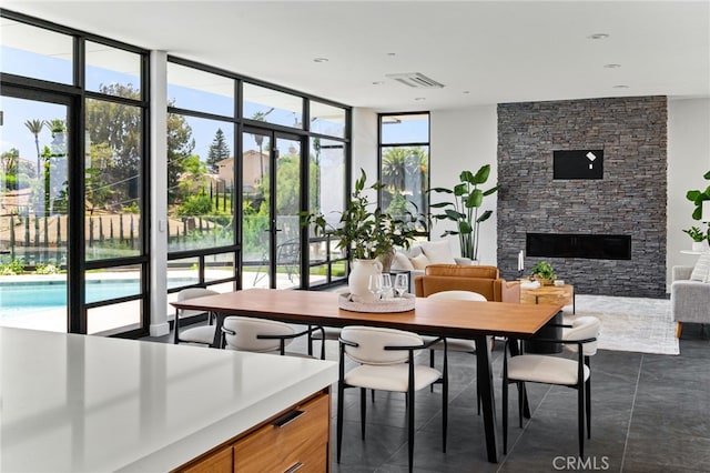 1912 Edgefair Ln, Redlands, CA 92373 - dining room featuring a wall of windows, a stone fireplace, and dark tile patterned flooring