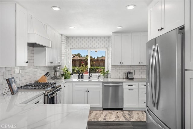 24532 La Cienega St, Laguna Hills, CA 92653 - kitchen with appliances with stainless steel finishes, custom range hood, white cabinetry, and recessed lighting