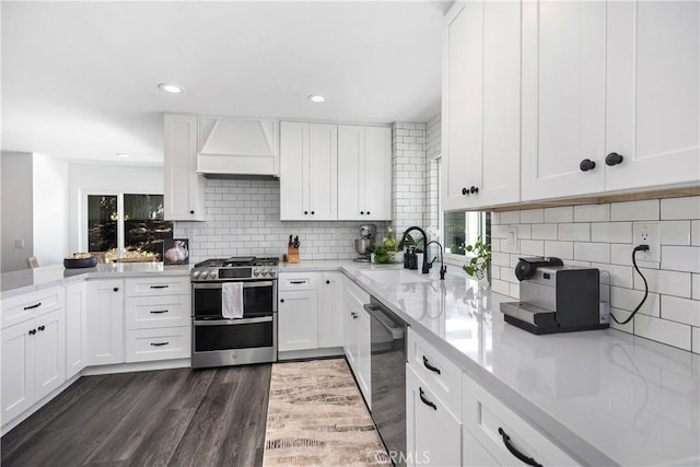 24532 La Cienega St, Laguna Hills, CA 92653 - kitchen with appliances with stainless steel finishes, premium range hood, dark wood finished floors, backsplash, and white cabinetry