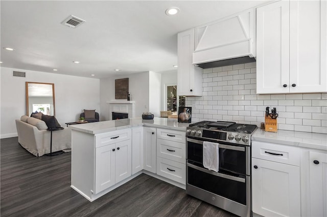 24532 La Cienega St, Laguna Hills, CA 92653 - kitchen featuring double oven range, a peninsula, custom range hood, open floor plan, and dark wood-style flooring