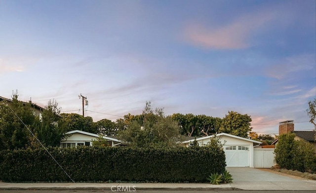 484 E 16th St, Costa Mesa, CA 92627 - view of property hidden behind natural elements with concrete driveway and a garage