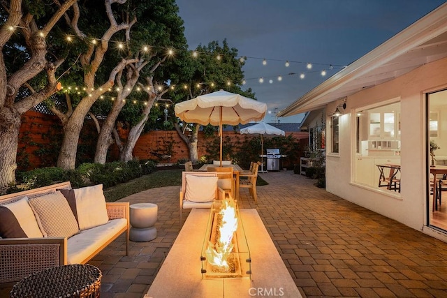 484 E 16th St, Costa Mesa, CA 92627 - patio at twilight with grilling area, an outdoor living space with a fire pit, a patio area, and a fenced backyard