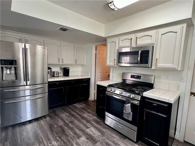 14016 Las Entradas, Bakersfield, CA 93314 - kitchen featuring appliances with stainless steel finishes, white cabinets, dark wood-type flooring, and dark cabinets