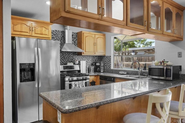 2164 Bluehaven Ct, San Diego, CA 92154 - kitchen with appliances with stainless steel finishes, wall chimney range hood, a peninsula, dark stone counters, and glass insert cabinets