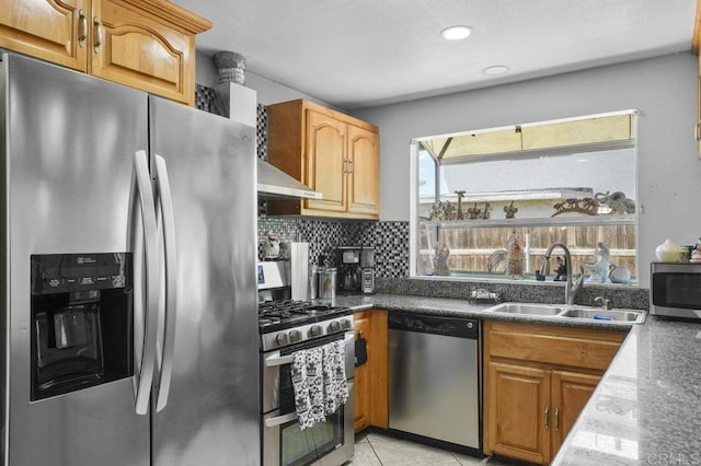 2164 Bluehaven Ct, San Diego, CA 92154 - kitchen featuring appliances with stainless steel finishes, wall chimney exhaust hood, decorative backsplash, dark countertops, and light tile patterned flooring