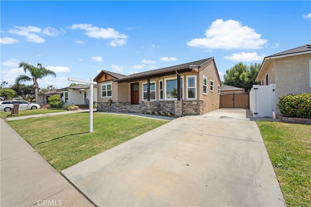 5116 Faust Ave, Lakewood, CA 90713 - view of front of home with a gate, concrete driveway, stucco siding, stone siding, and a front lawn