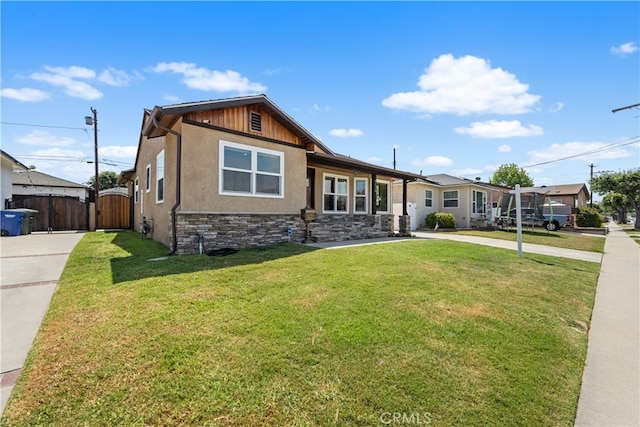 5116 Faust Ave, Lakewood, CA 90713 - view of front of home featuring a gate, stone siding, stucco siding, and a front lawn