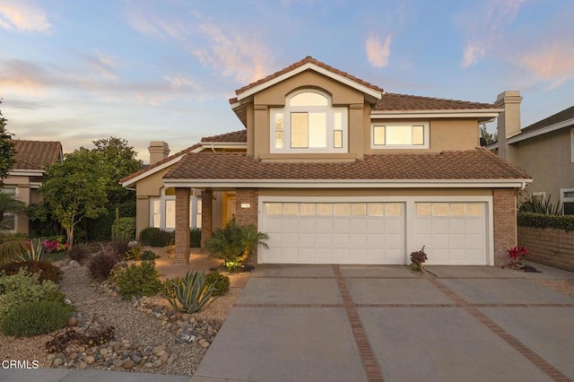 2106 Fox Den Ct, Oxnard, CA 93036 - view of front facade featuring driveway, brick siding, a tile roof, an attached garage, and stucco siding