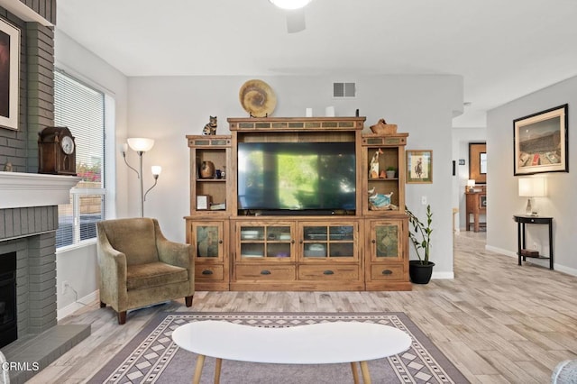 2106 Fox Den Ct, Oxnard, CA 93036 - living room with a brick fireplace, wood finished floors, plenty of natural light, and a ceiling fan