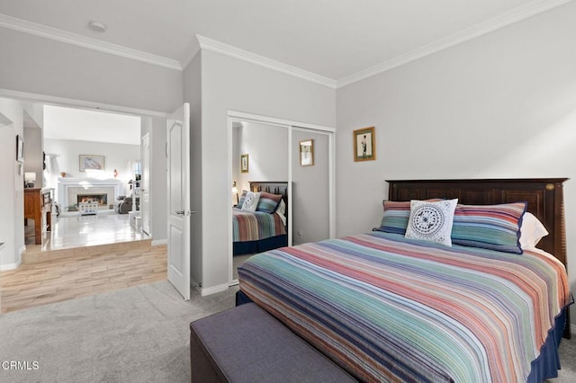 2106 Fox Den Ct, Oxnard, CA 93036 - bedroom featuring crown molding, carpet floors, a closet, and a warm lit fireplace