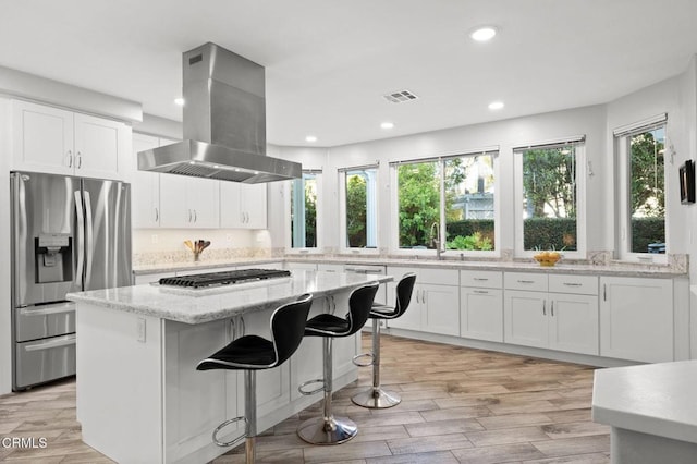 2106 Fox Den Ct, Oxnard, CA 93036 - kitchen featuring stainless steel appliances, island range hood, white cabinetry, a center island, and light stone counters