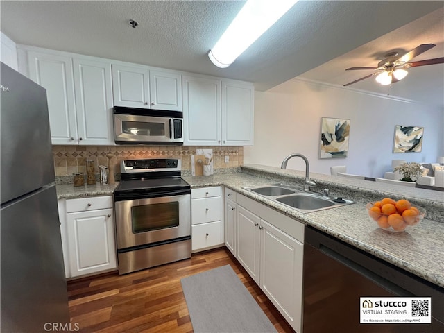 838 Pine Ave Unit 510, Long Beach, CA 90813 - kitchen with appliances with stainless steel finishes, dark wood-style floors, backsplash, white cabinets, and a ceiling fan