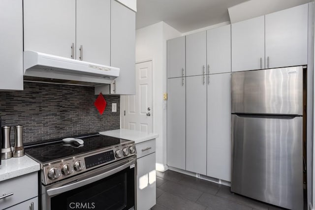 17 Carnegie, San Jose, CA 95116 - kitchen featuring stainless steel appliances, under cabinet range hood, decorative backsplash, dark tile patterned flooring, and light stone countertops
